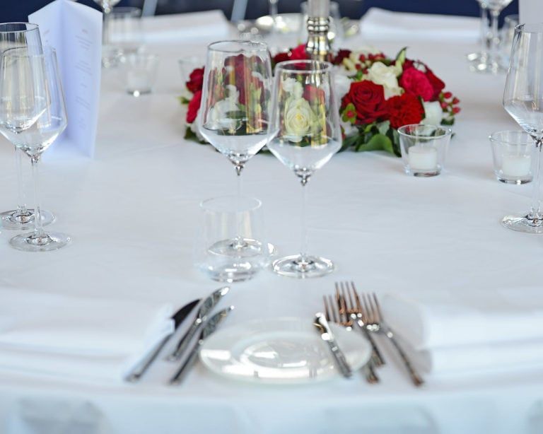 Gedeckter Tisch, mit Weingläsern, Besteck und Blumen