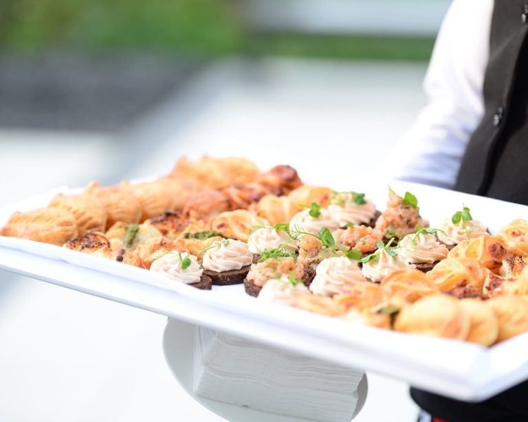 Weißes Tablett, mit verschiedenen Häppchen drauf.